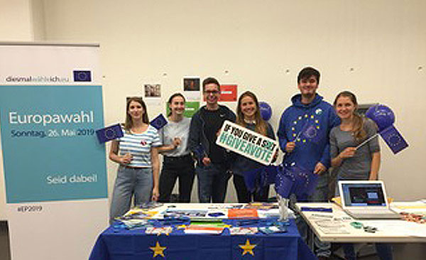Ein Gruppe junger Leute halten Schilder zur Europawahl hoch.