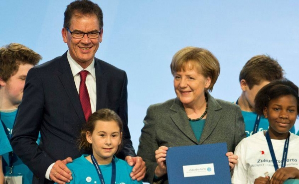 Entwicklungsminister Müller und Bundeskanzlerin Merkel mit der gedruckten Zukunftscharta